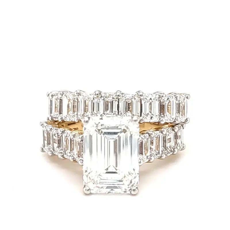 Diamond engagement ring with large emerald-cut center stone and baguette side stones on a white background