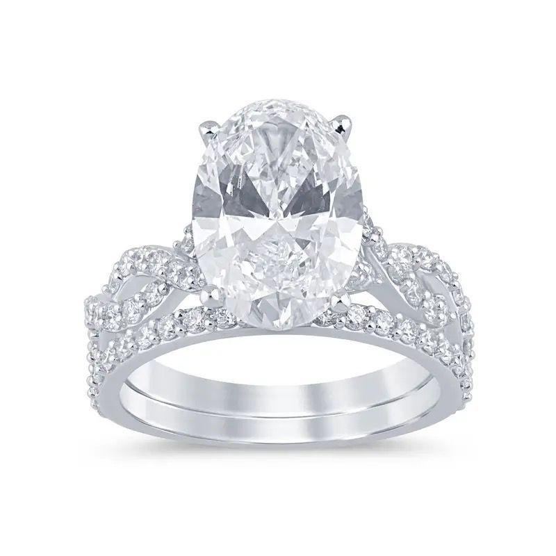 Oval diamond engagement ring with pavé band on a white background