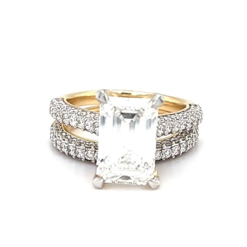 Gold ring with large rectangular diamond and two pavé bands on white background