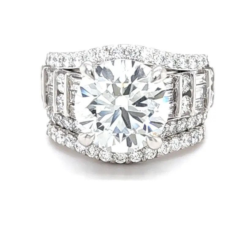Large oval diamond ring with pavé band and side stones on a white background