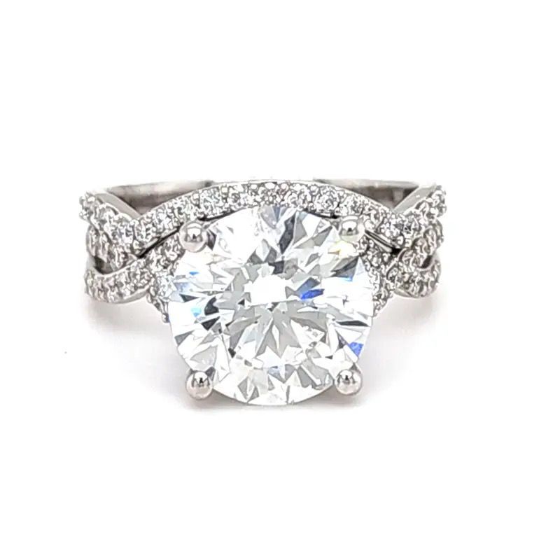 Diamond engagement ring with a large round center stone and pavé-set band on a white background