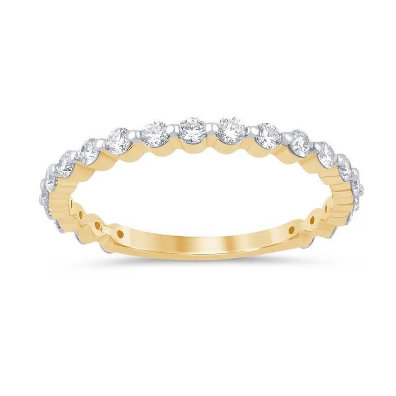 Gold ring with scalloped band and row of clear gemstones across the top