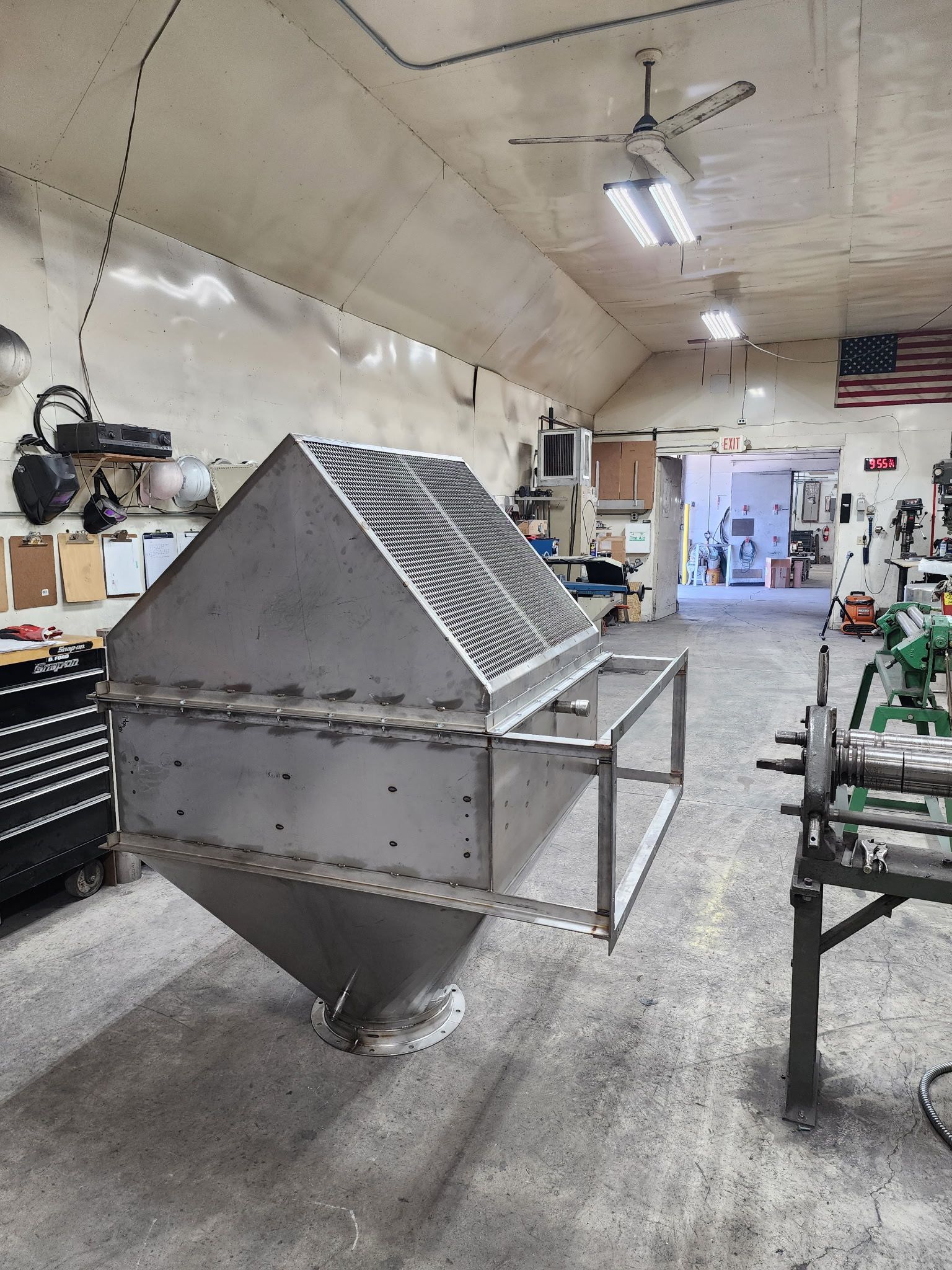 Large metal hopper, welded construction, in a workshop setting.
