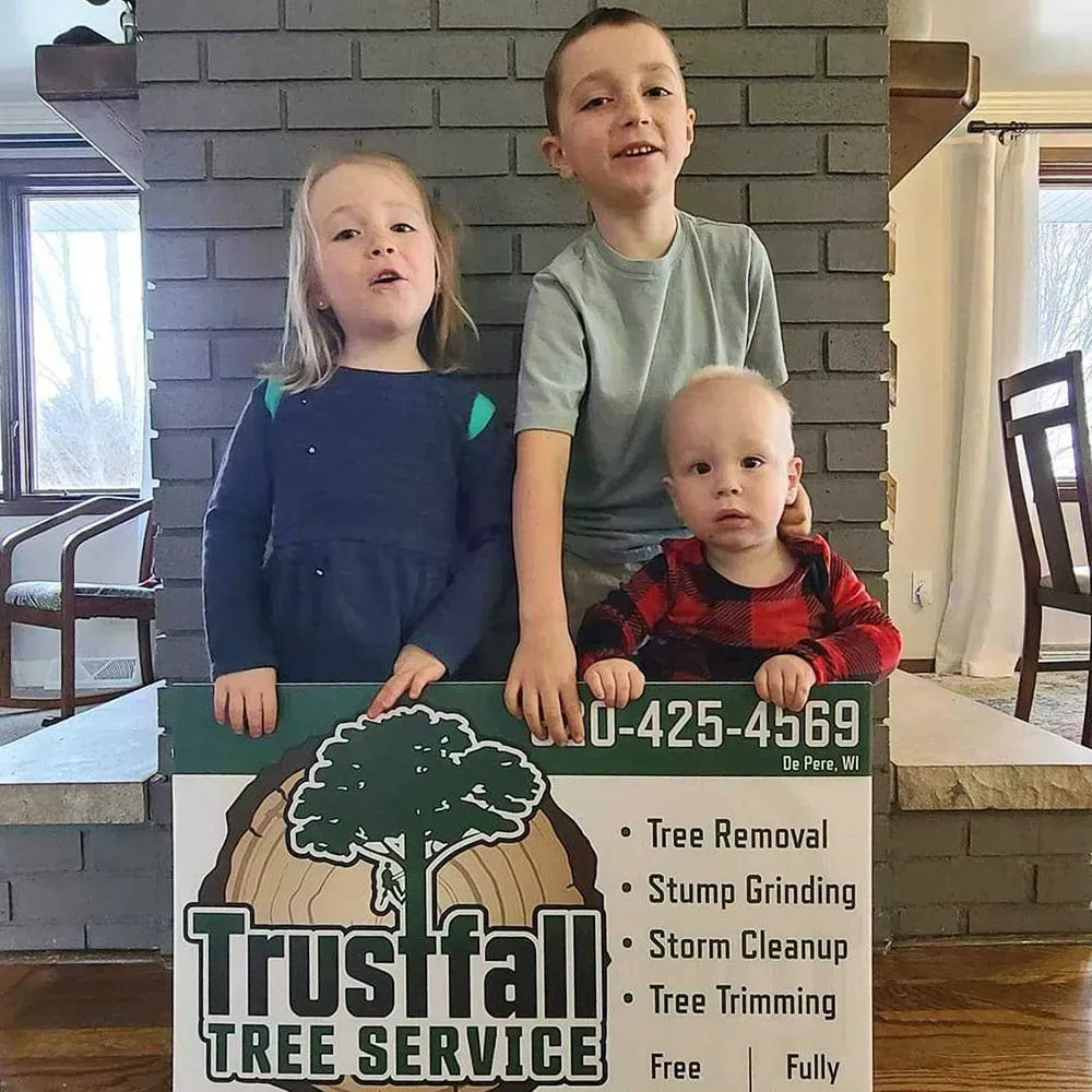 Three children standing next to a sign that says trustfall tree service