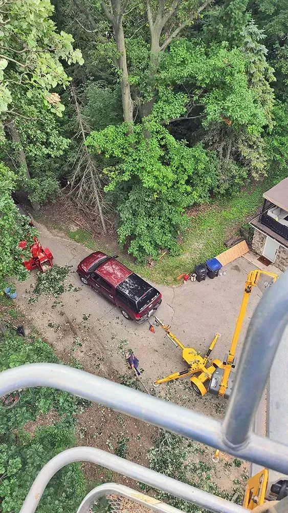 A car is sitting on the side of a road next to a crane.