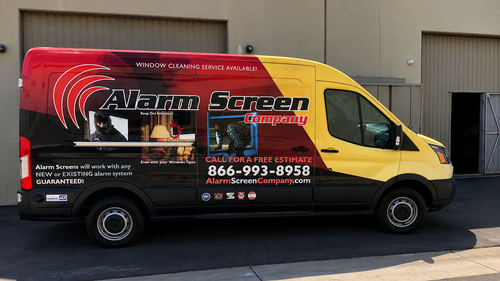 Red and yellow Alamo Screen service van parked outdoors with company logo and phone number.
