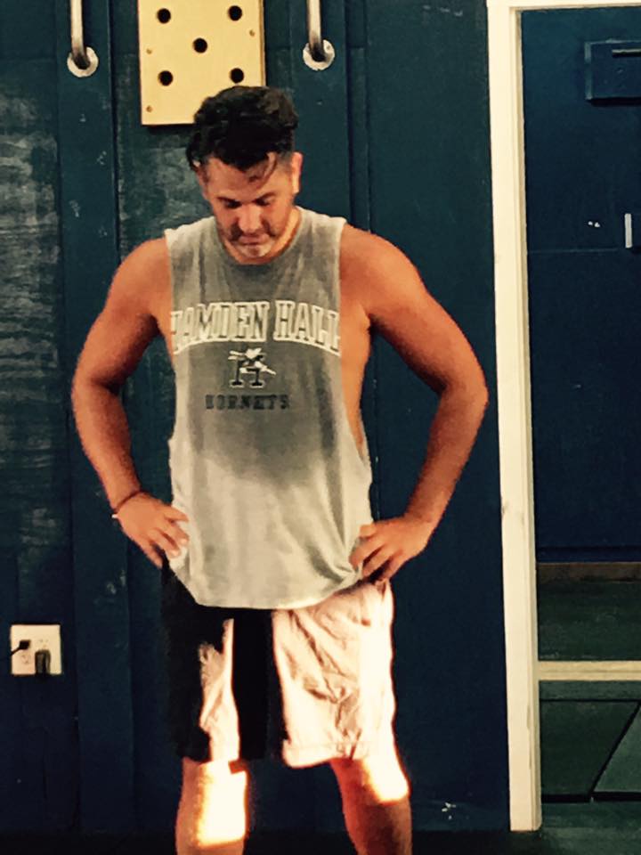 A man wearing a tank top with the word hornets on it