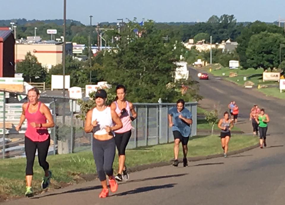 A group of people are running down a road