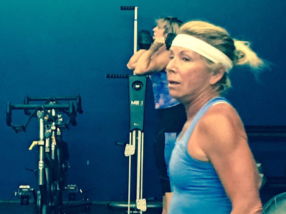 A woman in a blue tank top is wearing a white headband