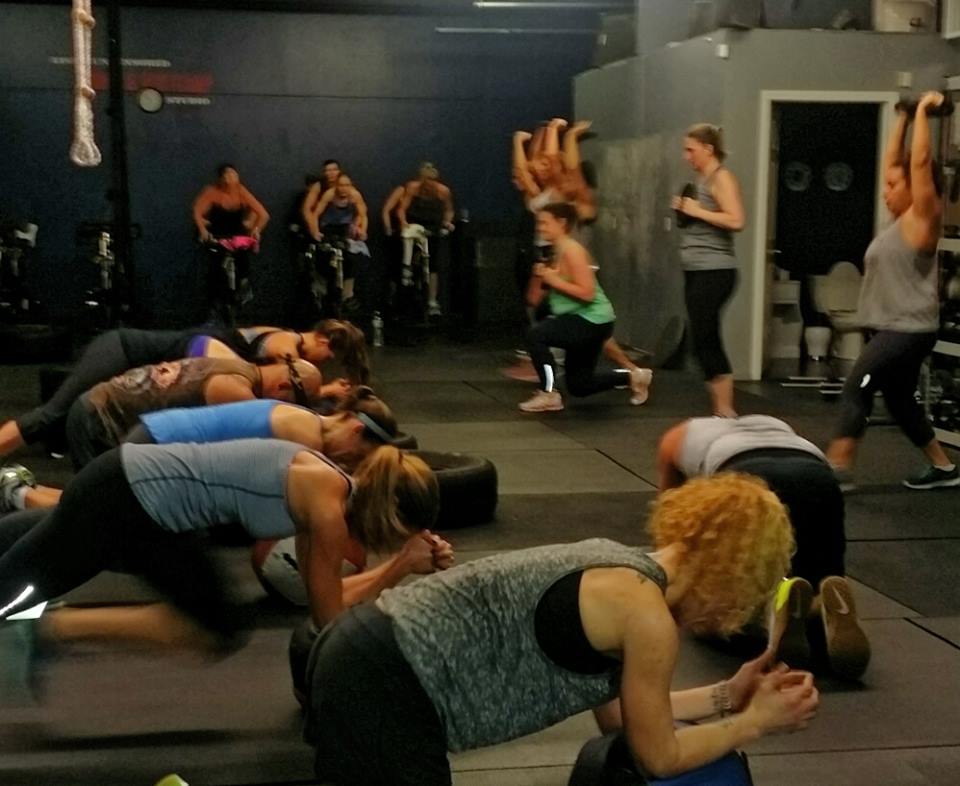 A group of women are doing stretching exercises in a gym