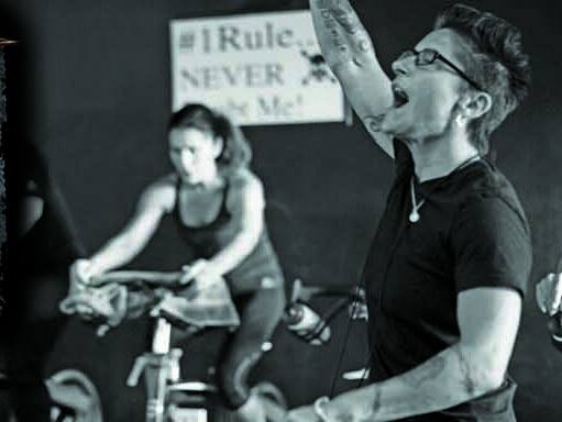 A black and white photo of a woman riding an exercise bike.
