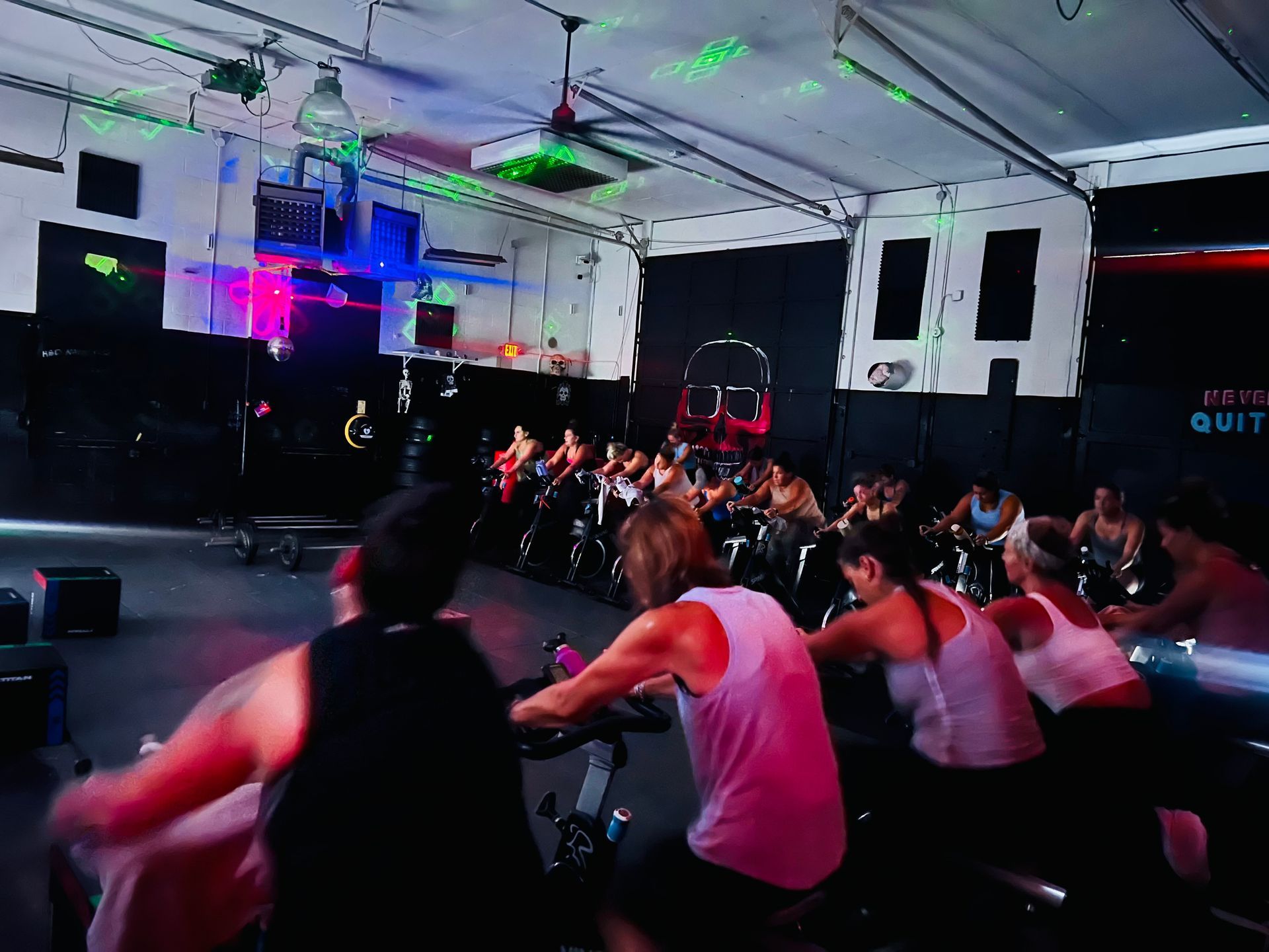A group of people are riding exercise bikes in a gym.