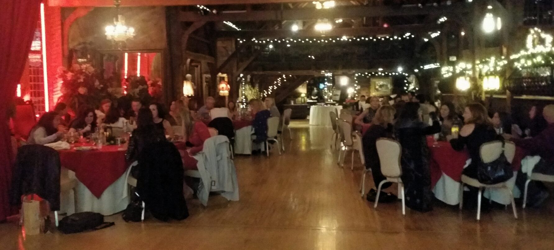 A group of people are sitting at tables in a large room.