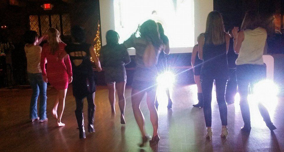 A group of people are dancing in a dark room.