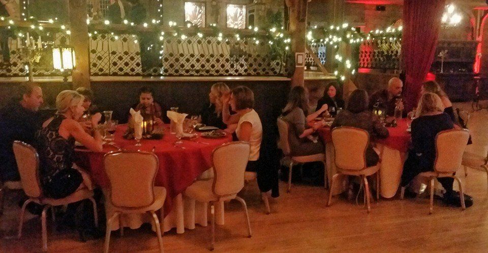 A group of people are sitting at tables in a restaurant.