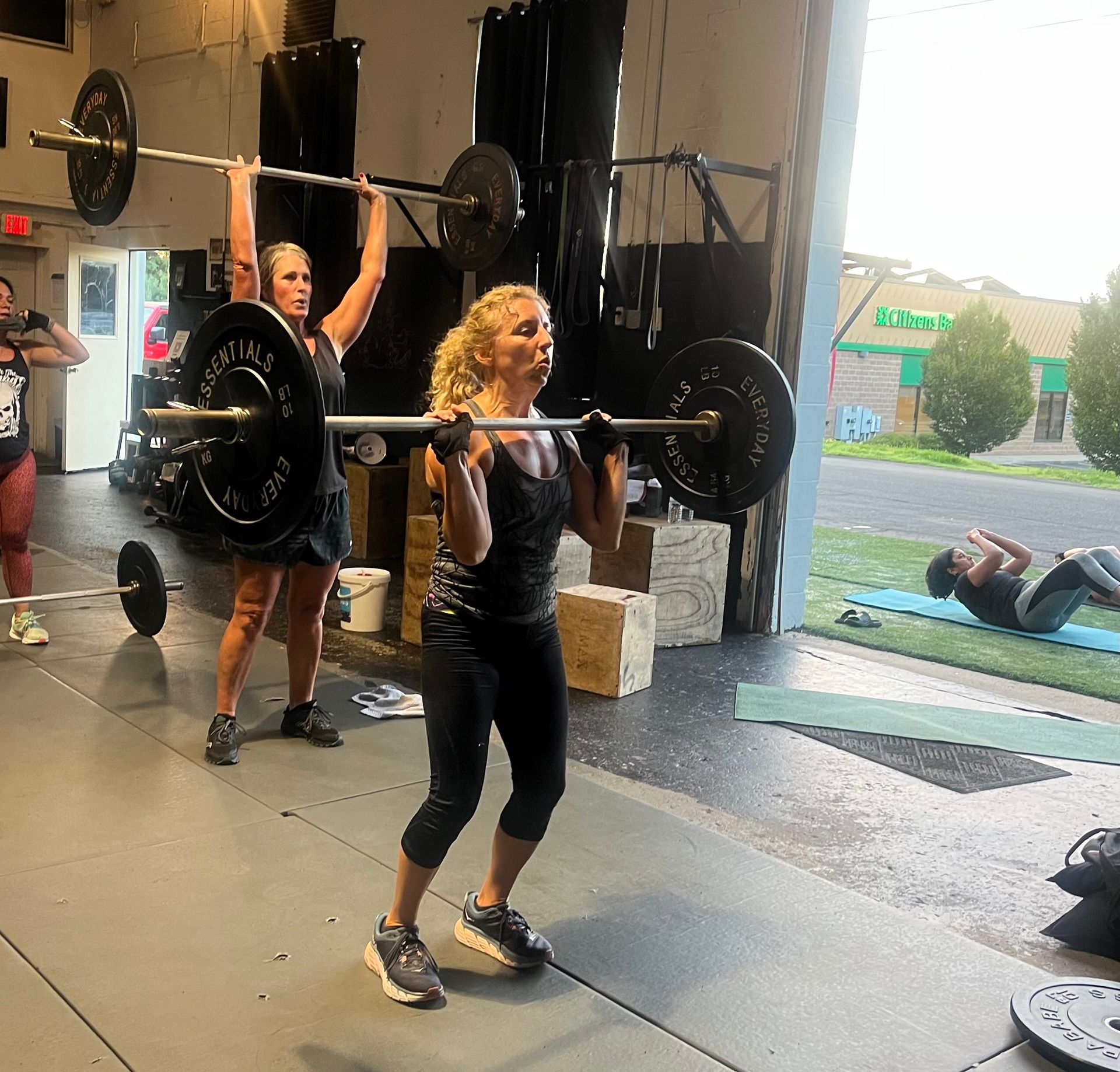 A woman is lifting a barbell in a gym