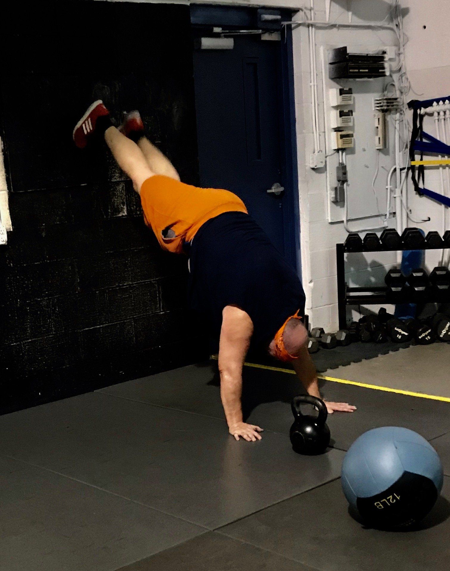 A man is doing a handstand in a gym