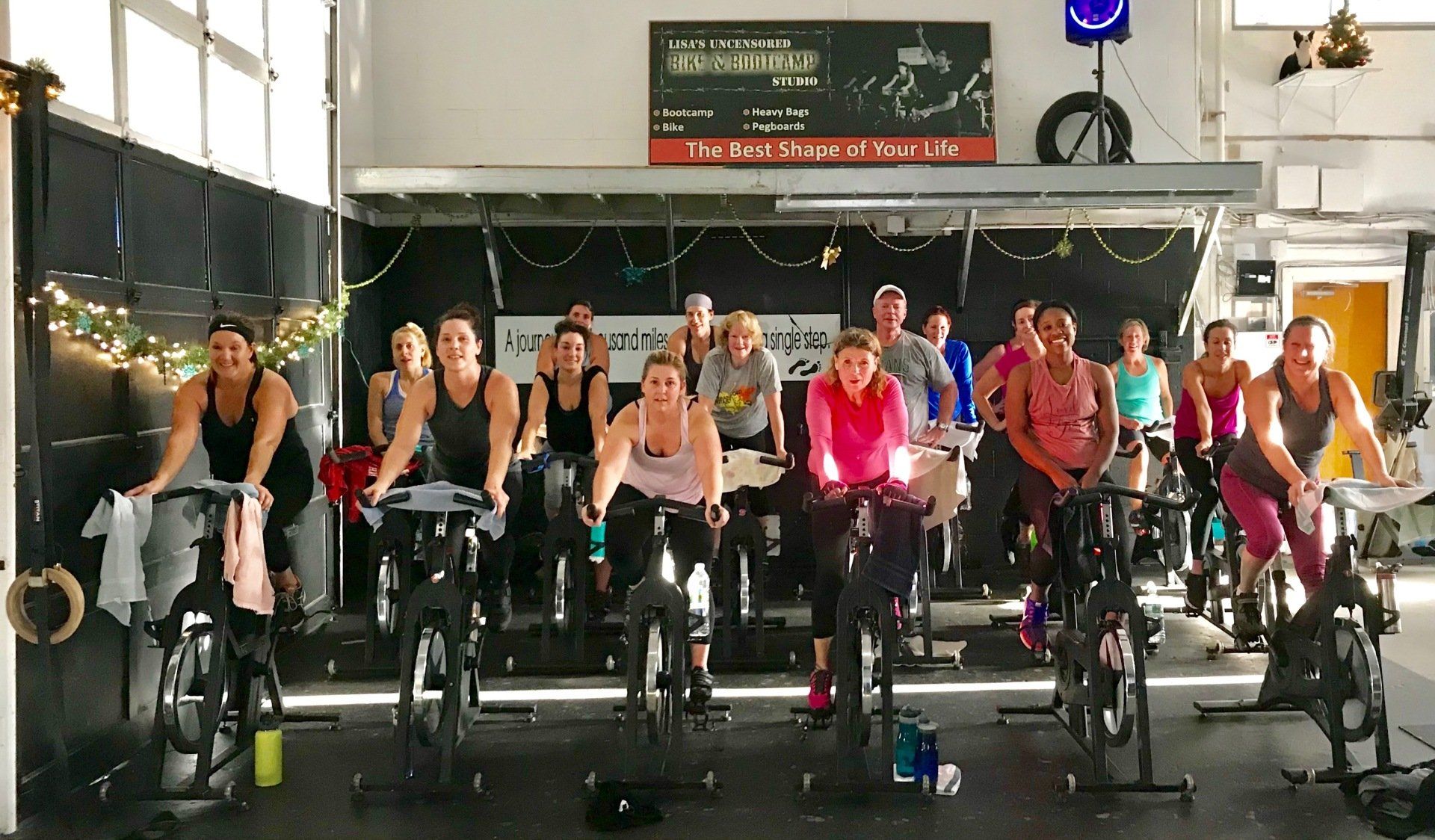 A group of people are riding exercise bikes in a gym.