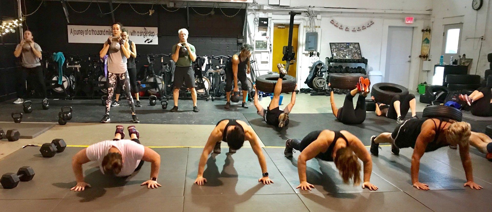 A group of people are doing push ups in a gym.