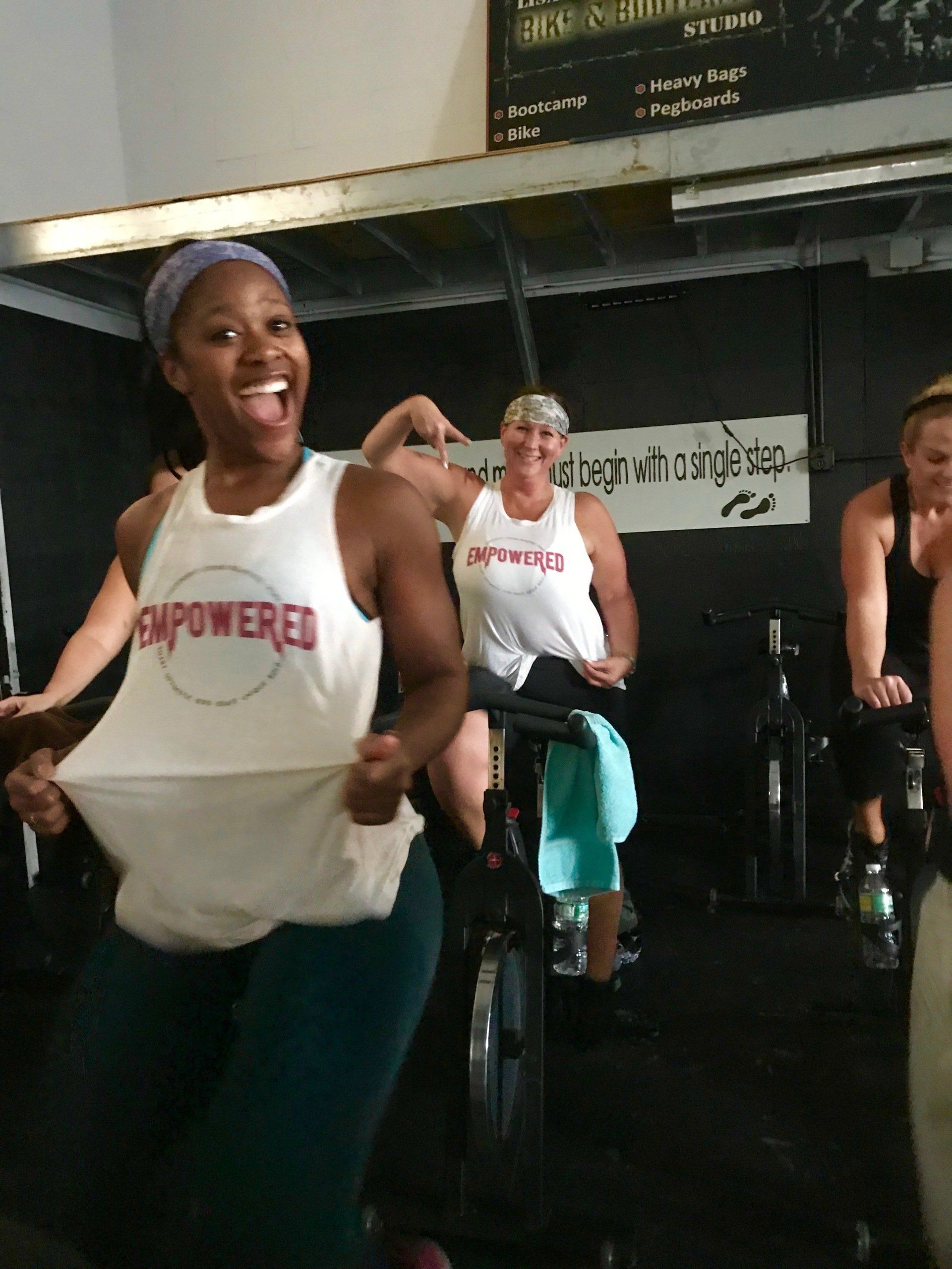 A woman wearing a white tank top that says empowered