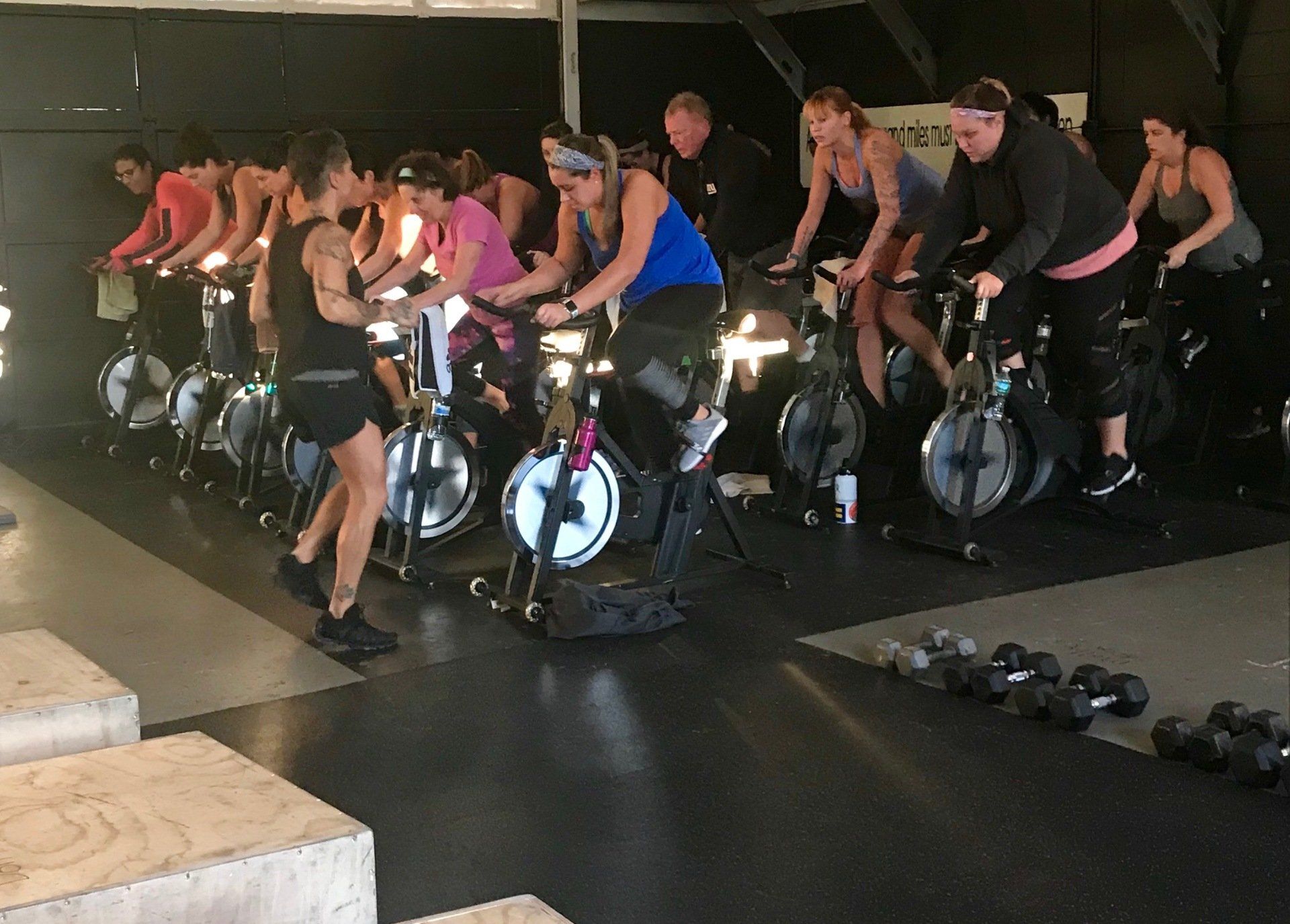 A group of people are riding exercise bikes in a gym.