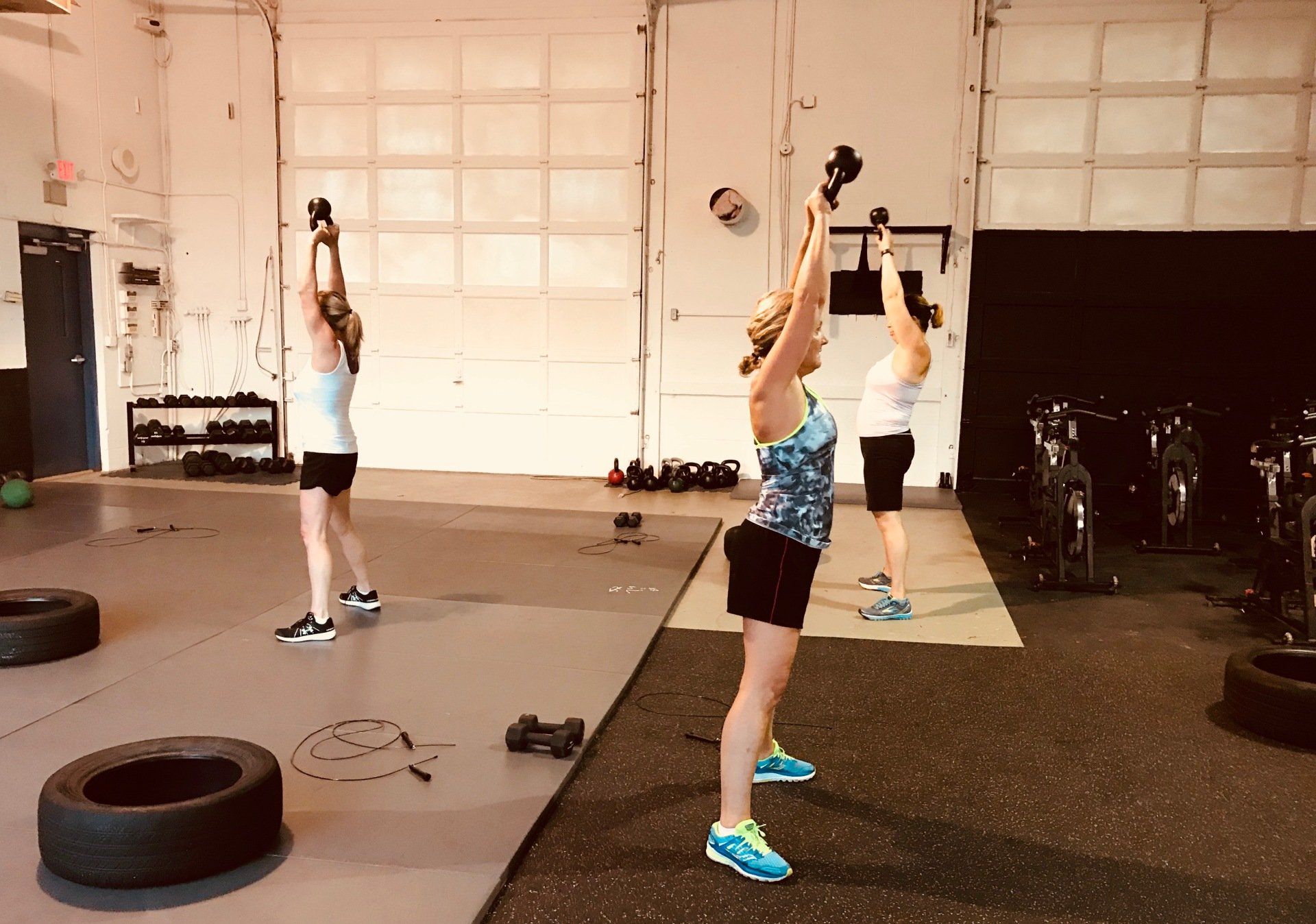 A group of women are doing exercises in a gym.
