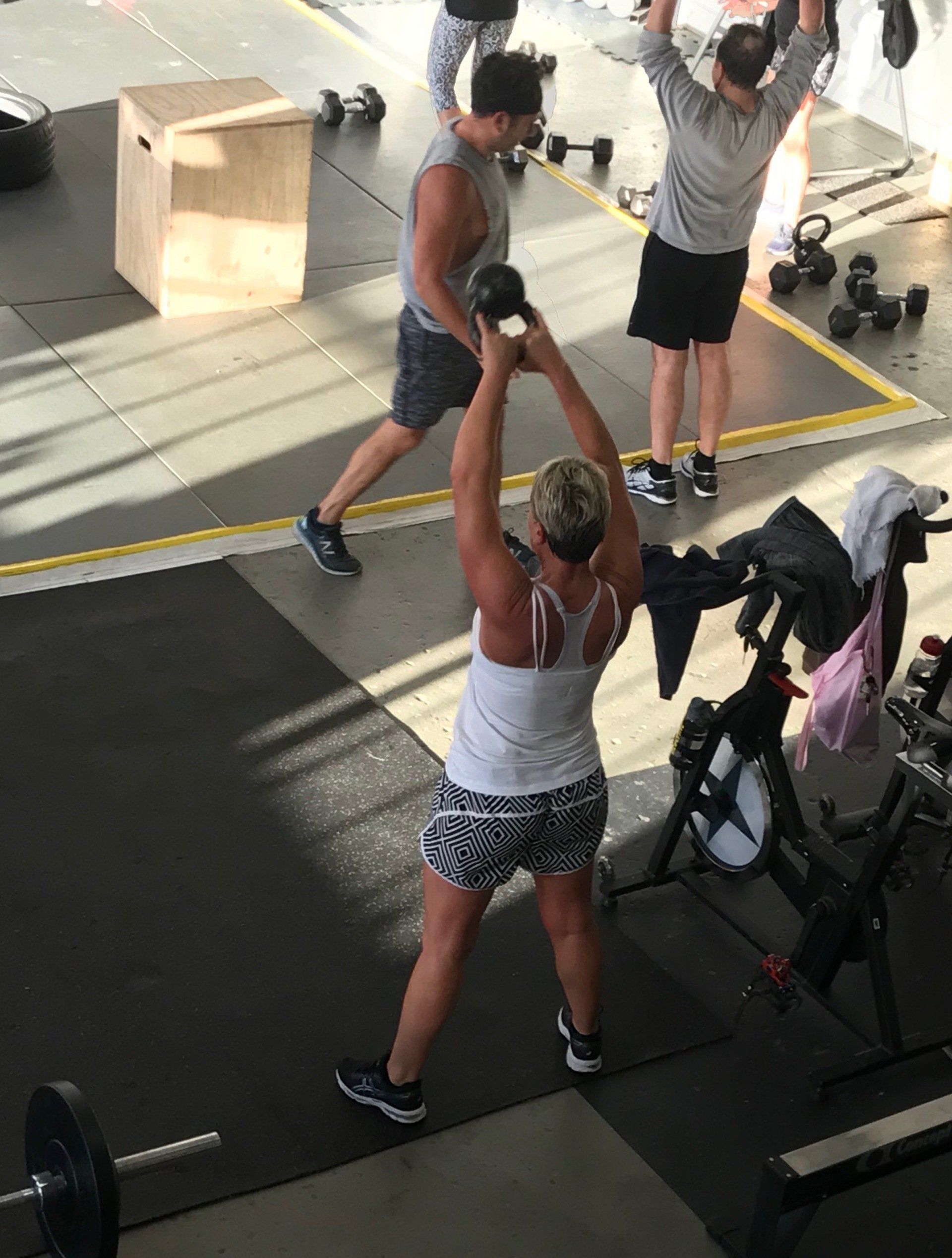 A group of people are lifting weights in a gym.