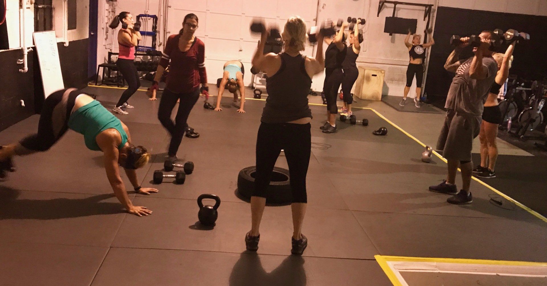 A group of people are doing exercises in a gym.