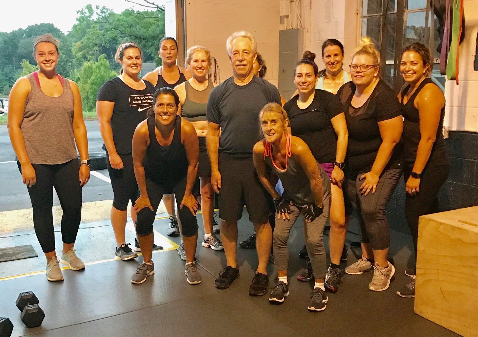 A group of people are posing for a picture in a gym.
