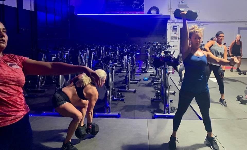 A group of people are doing exercises in a gym.