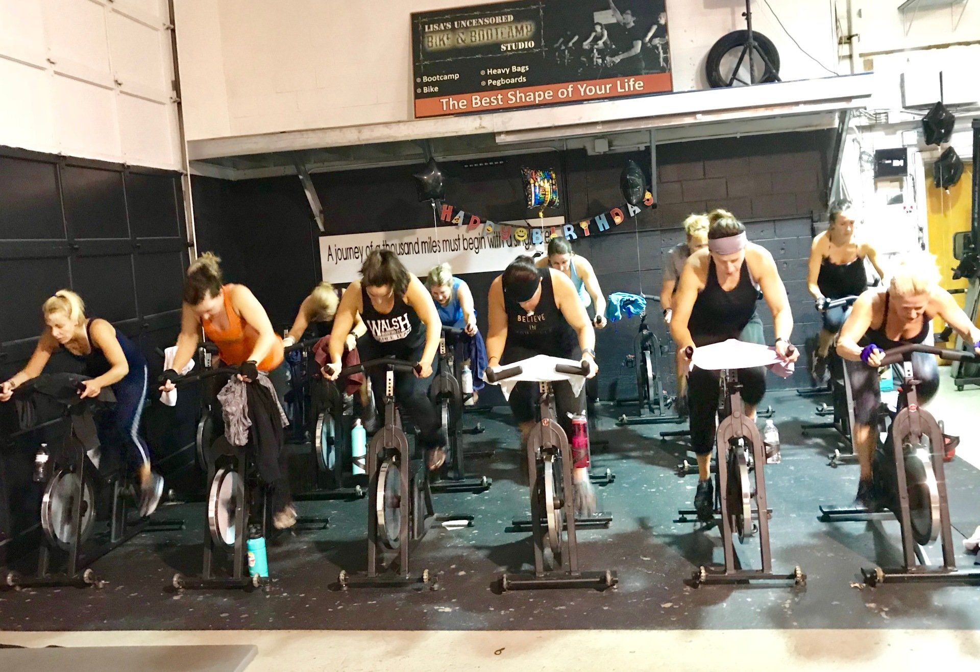 A group of women are riding exercise bikes in a gym.