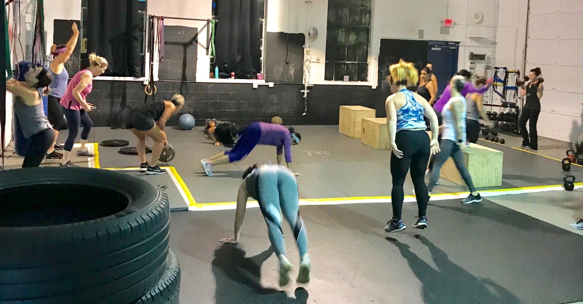 A group of people are doing exercises in a gym.