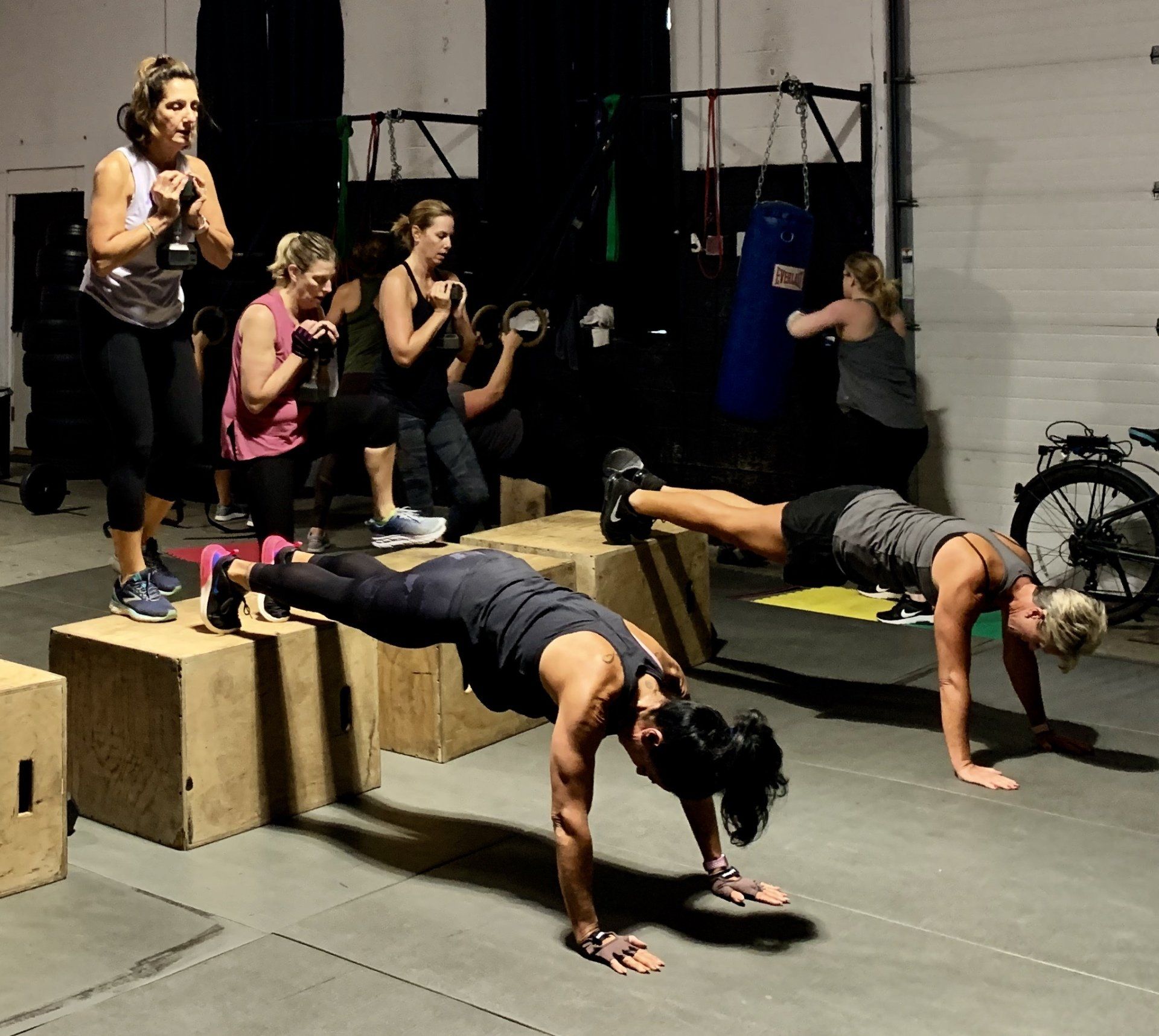 A group of women are doing push ups in a gym.