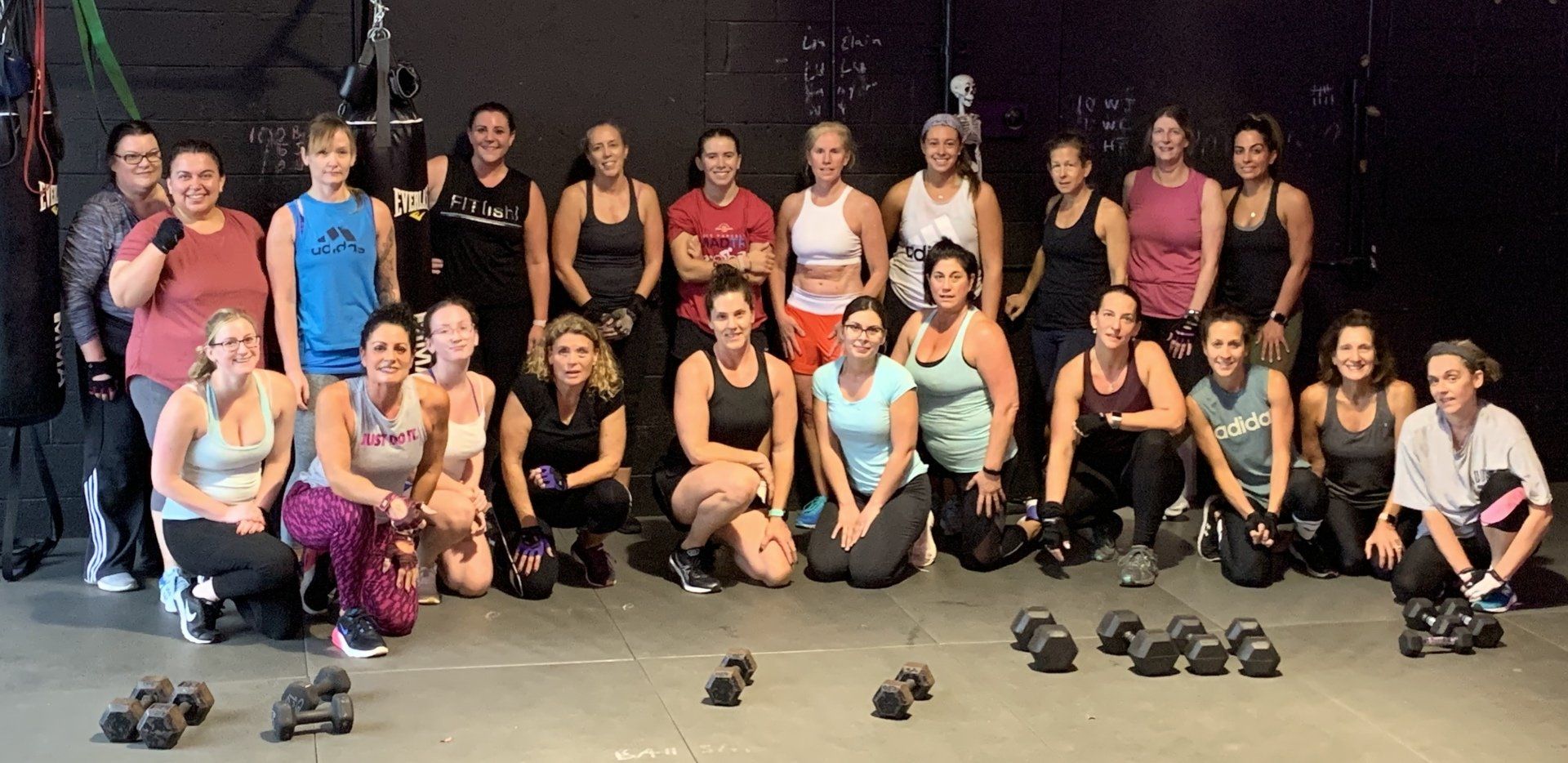 A group of women are posing for a picture in a gym.