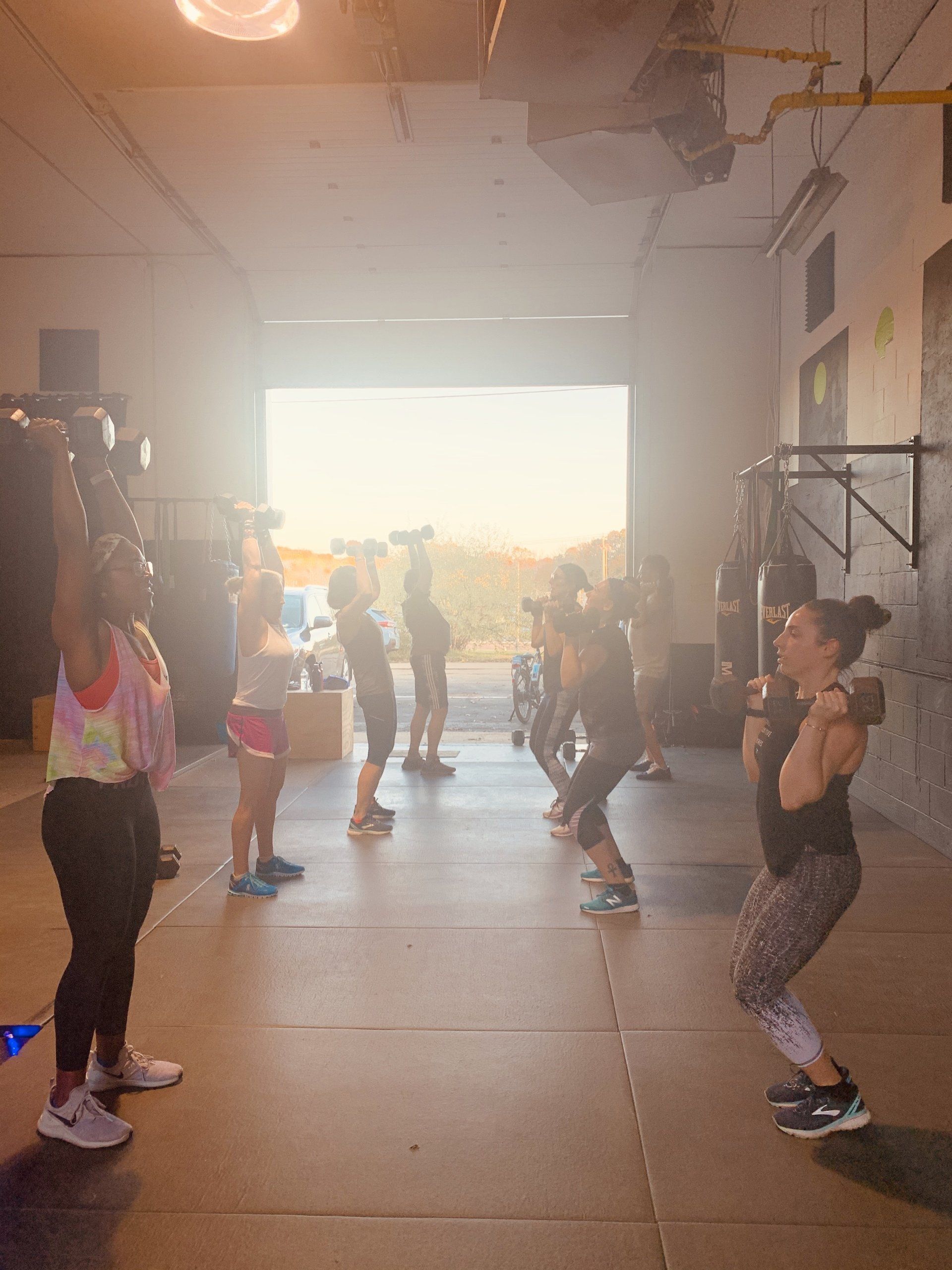 A group of people are doing squats in a gym.
