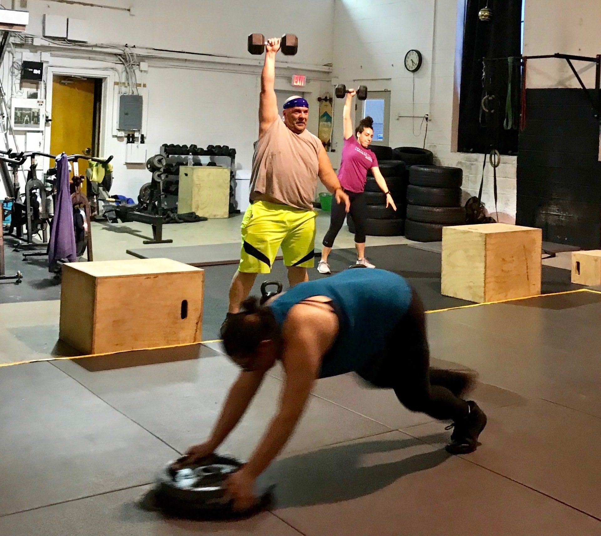 A group of people are doing exercises in a gym