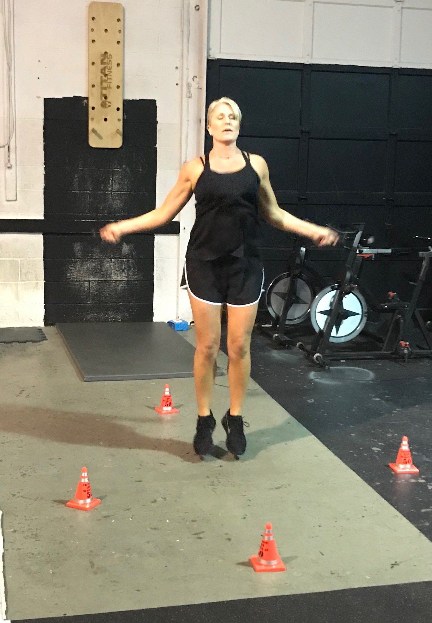 A woman is jumping a jump rope in a gym