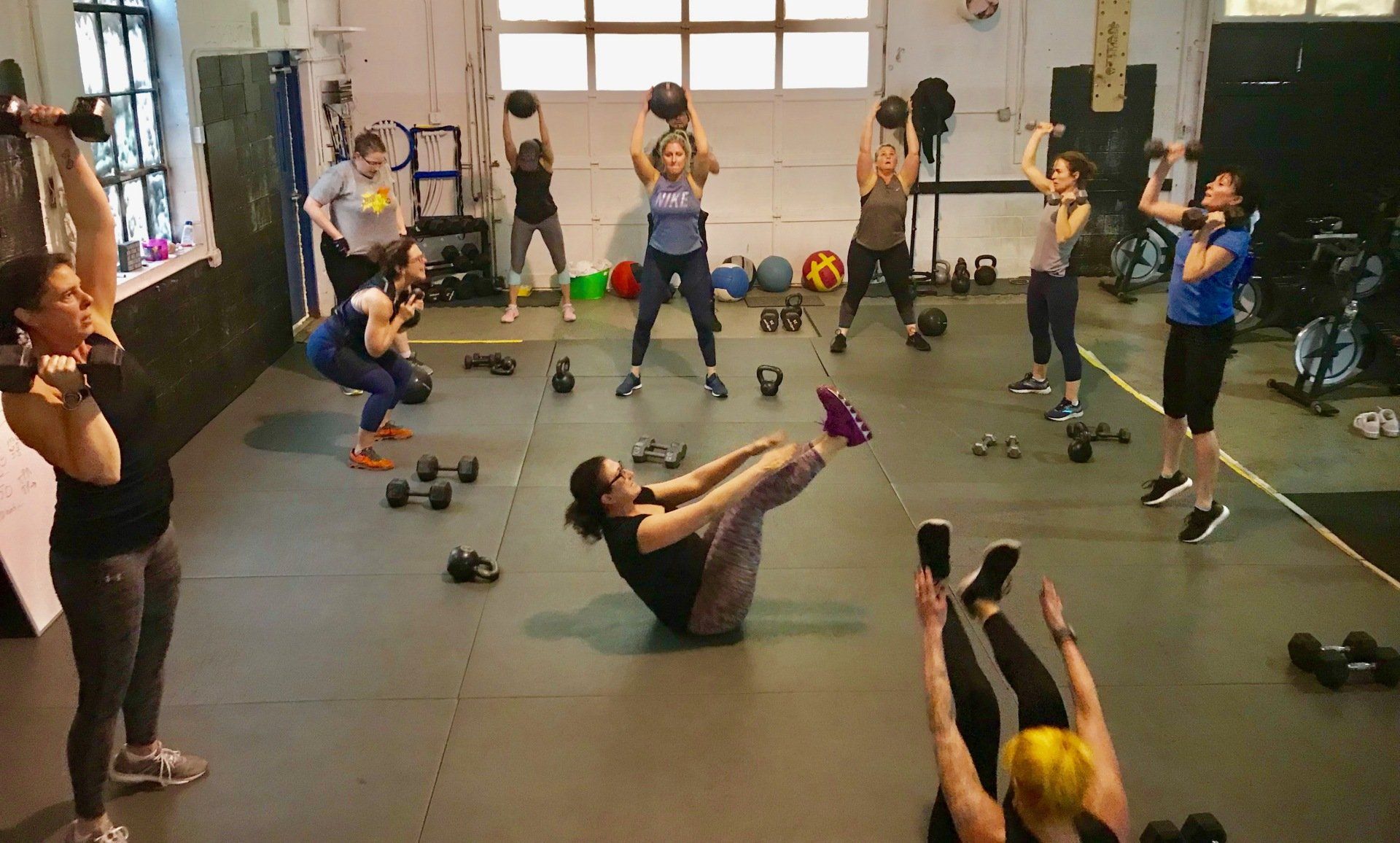A group of people are doing exercises in a gym.