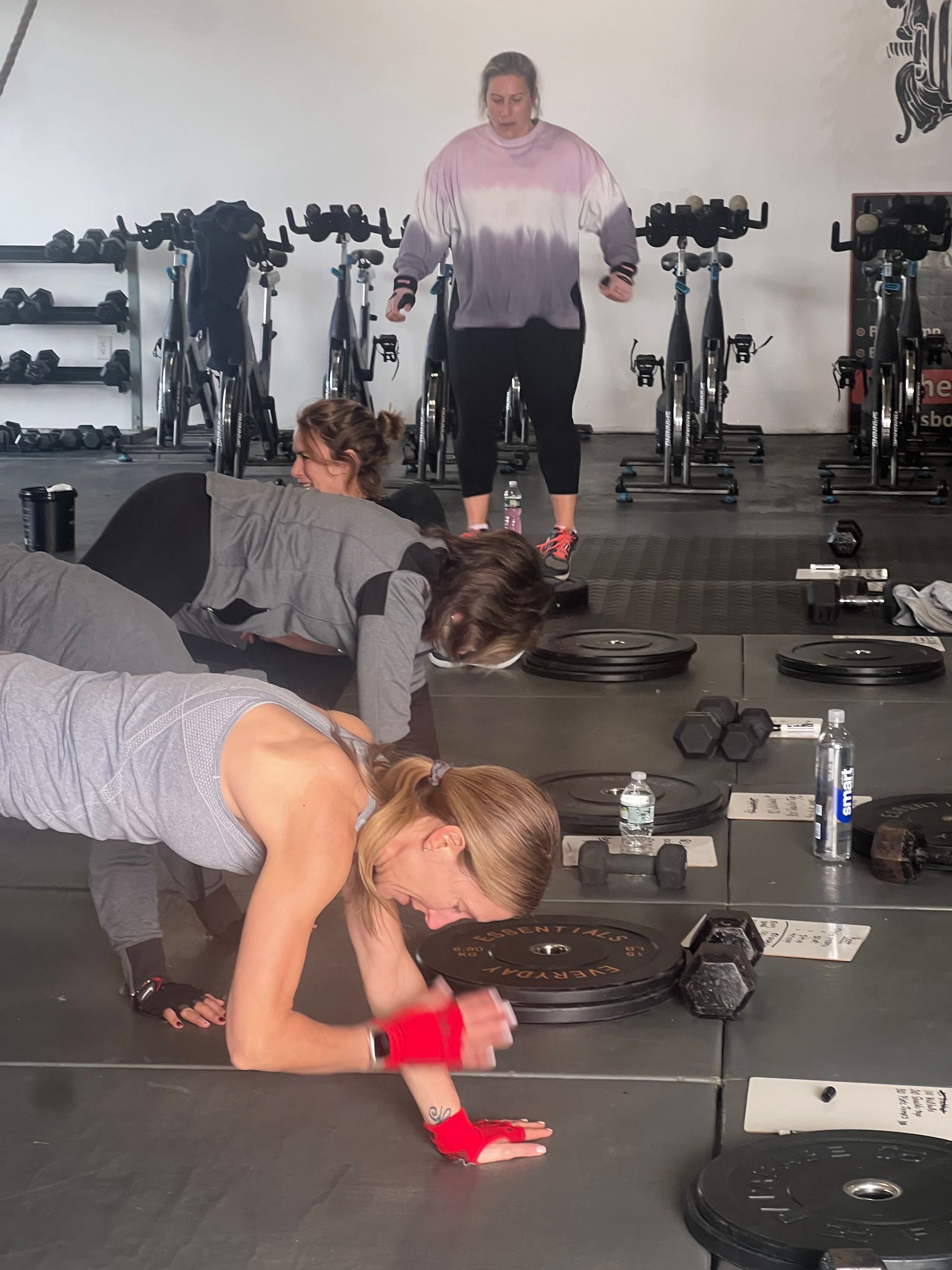 A group of people are doing push ups in a gym
