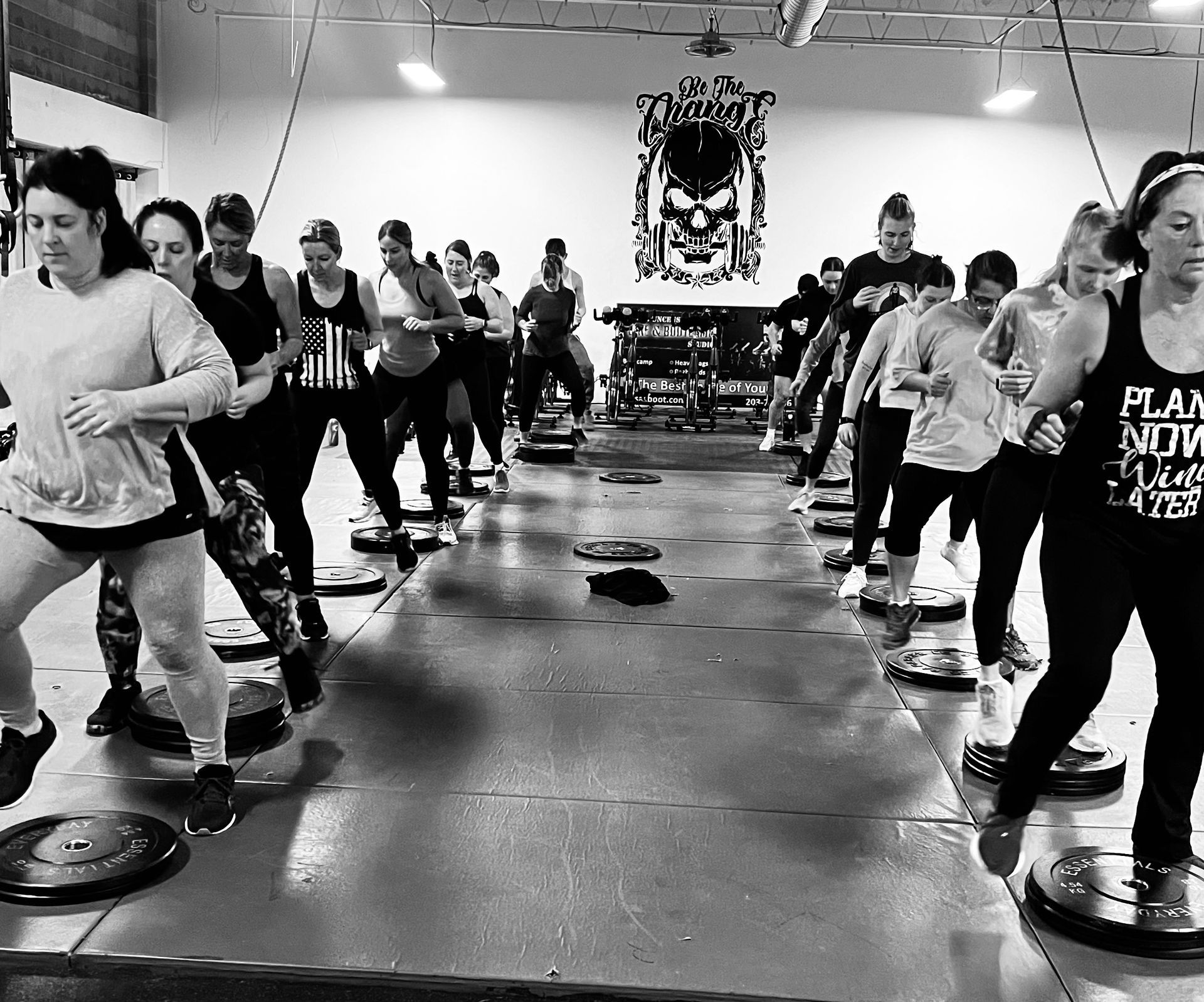 A black and white photo of a group of people dancing in a gym.