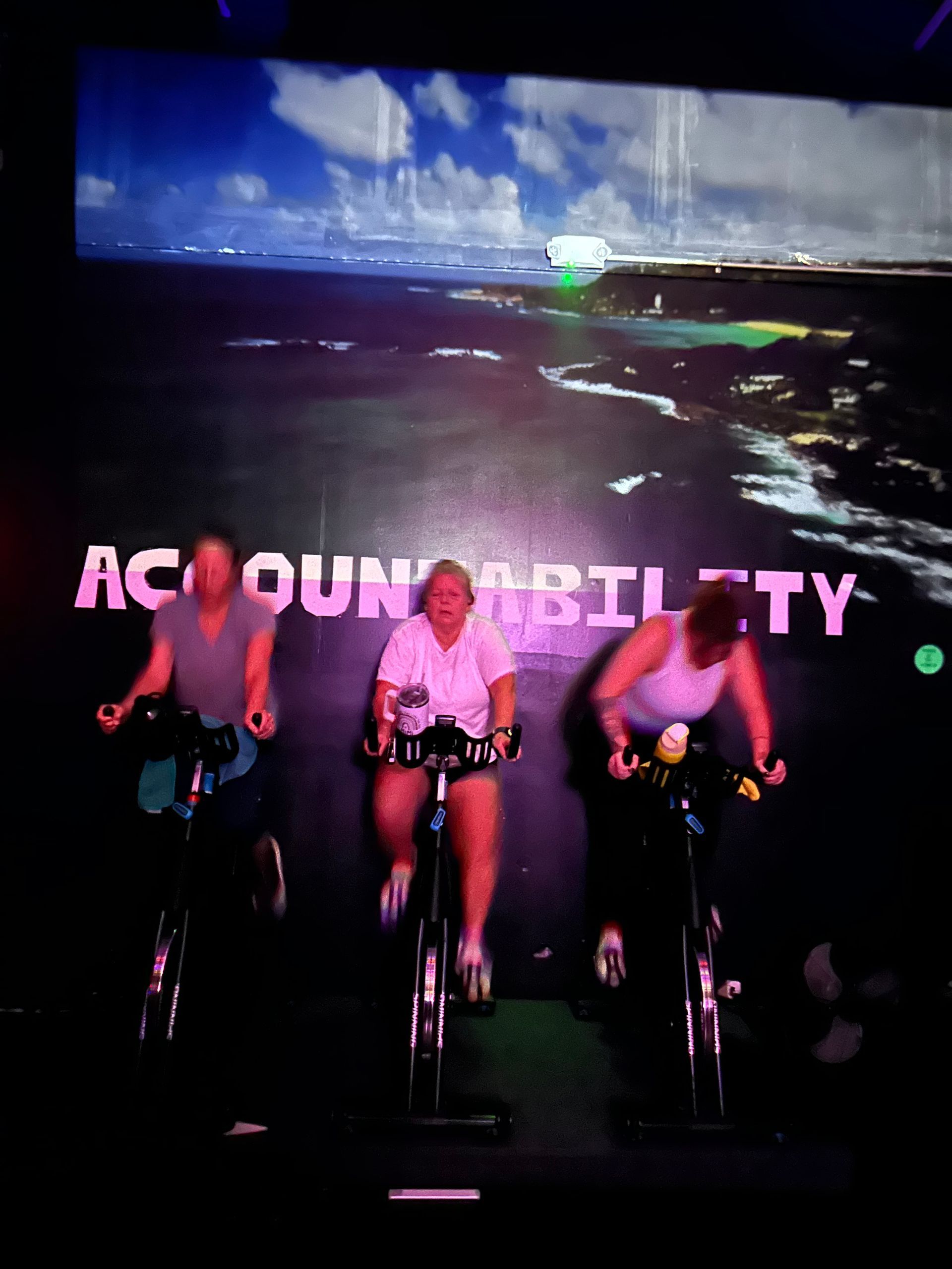 Three cyclists on exercise bikes