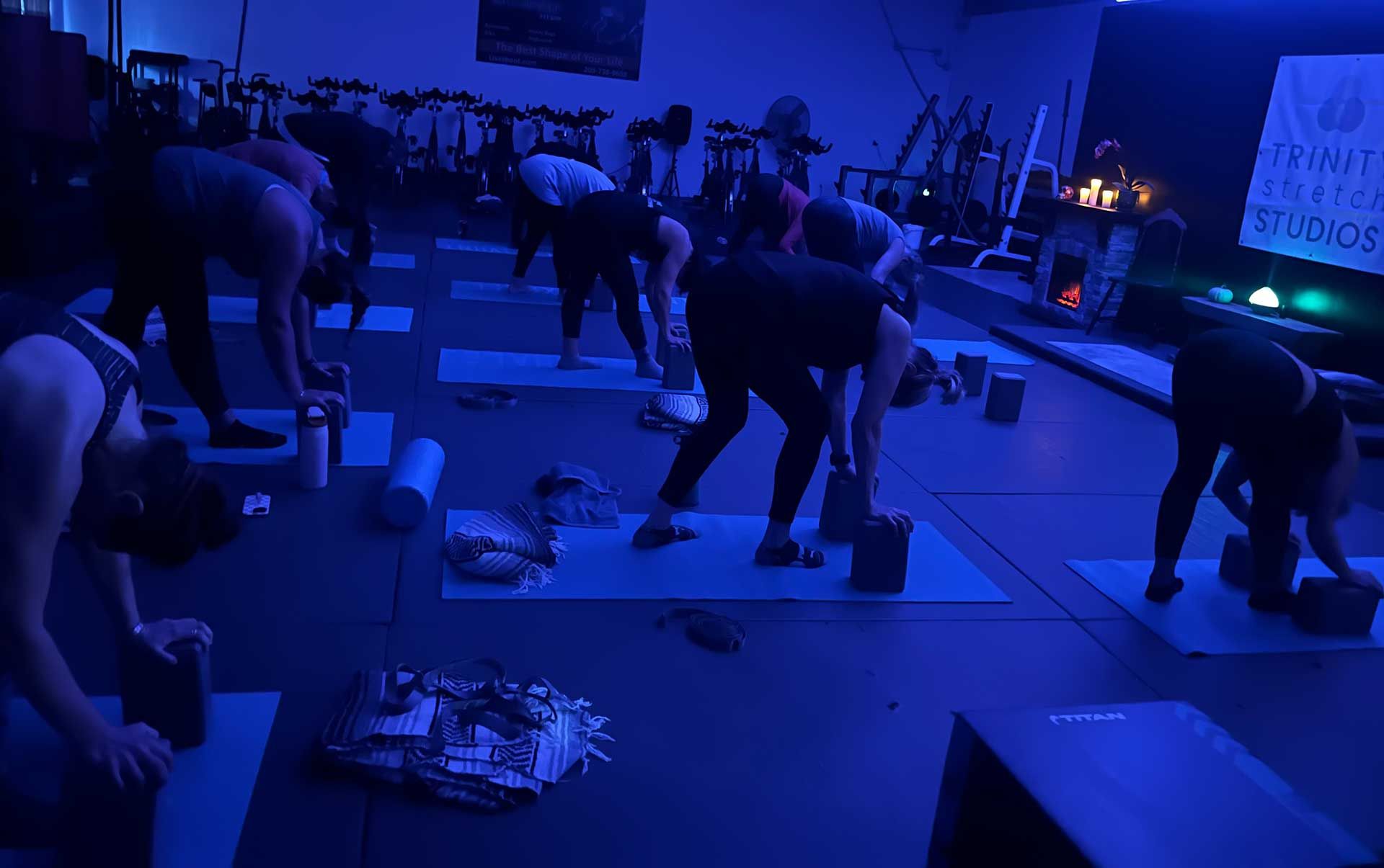 A group of people are doing yoga in a gym