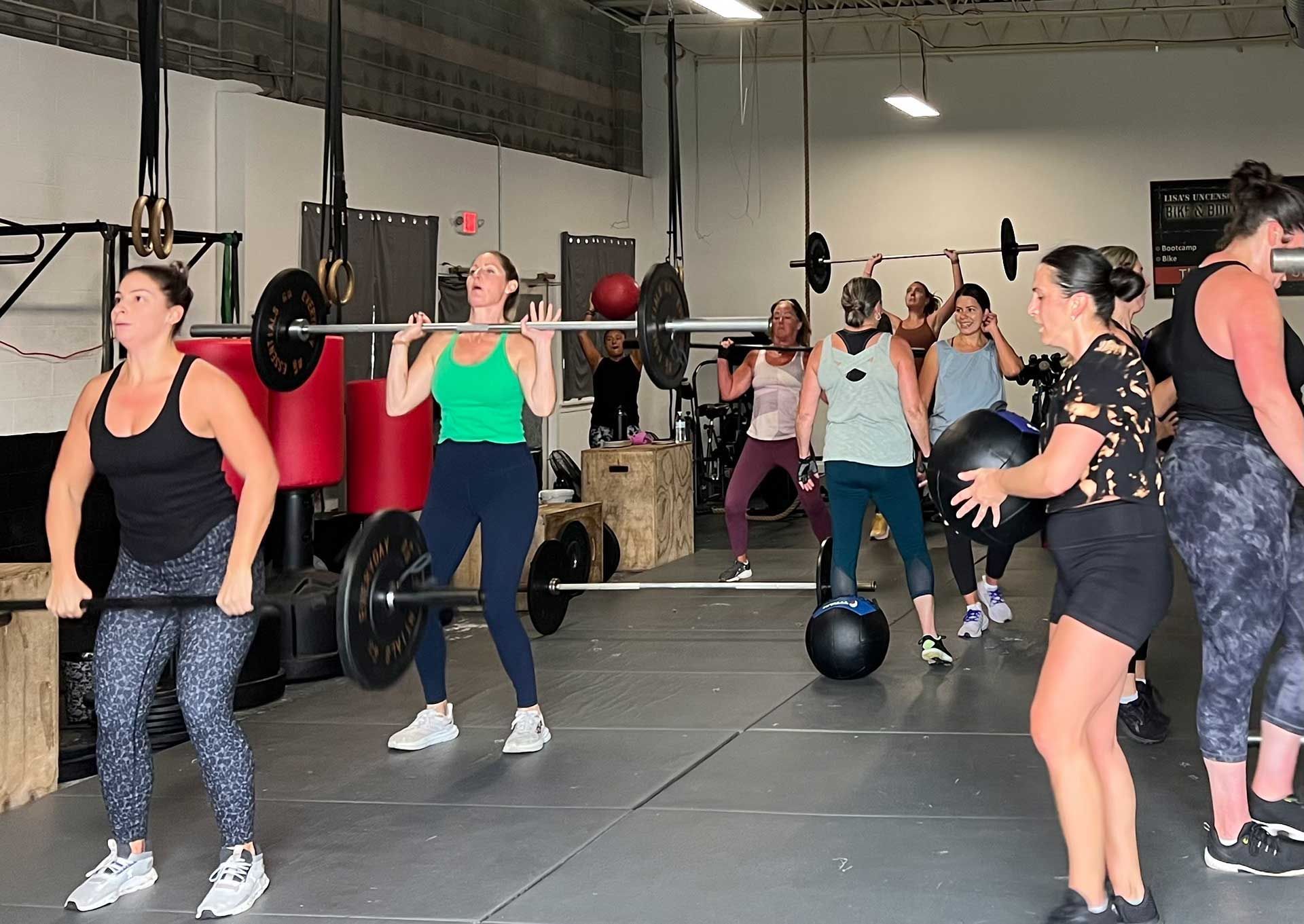 A group of women are weightlifting in a gym