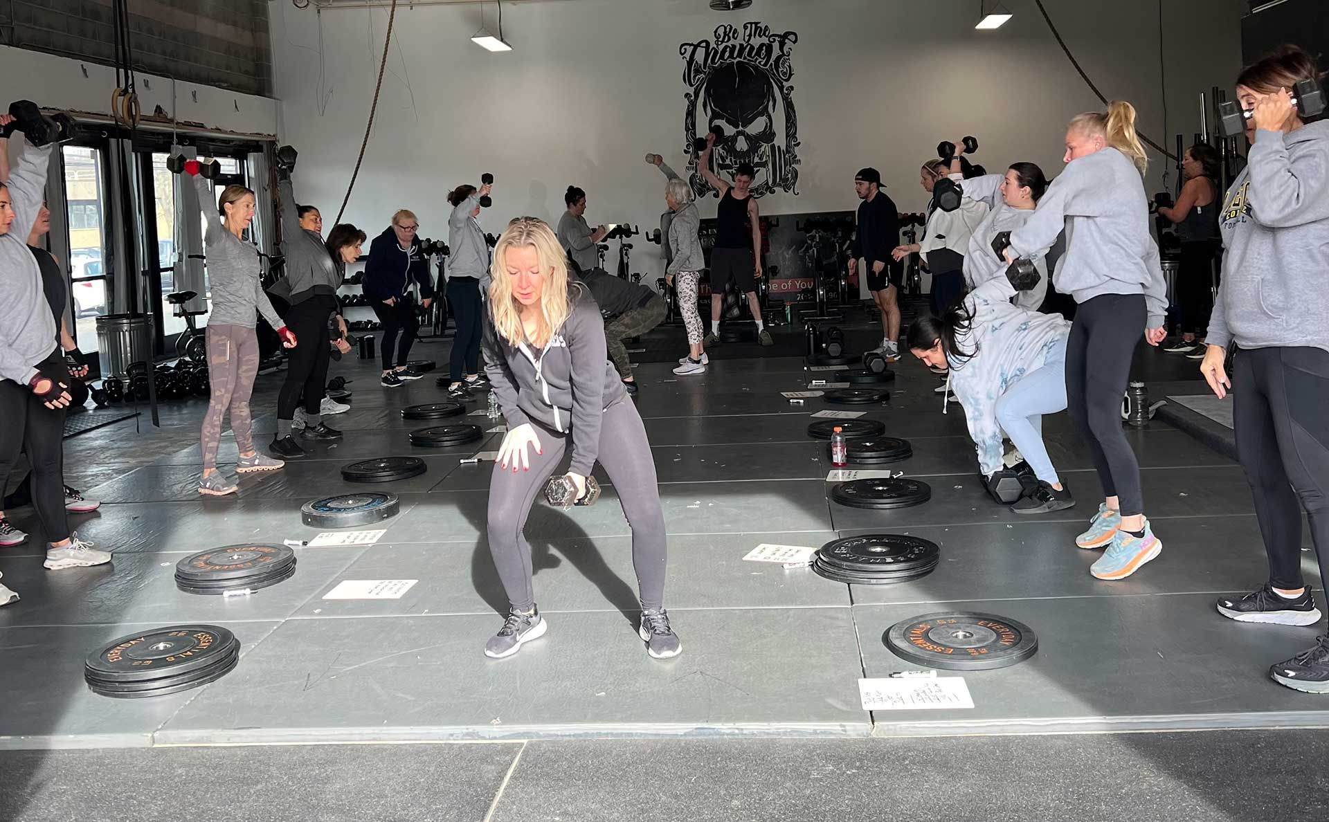 A group of people are lifting dumbbells in a gym