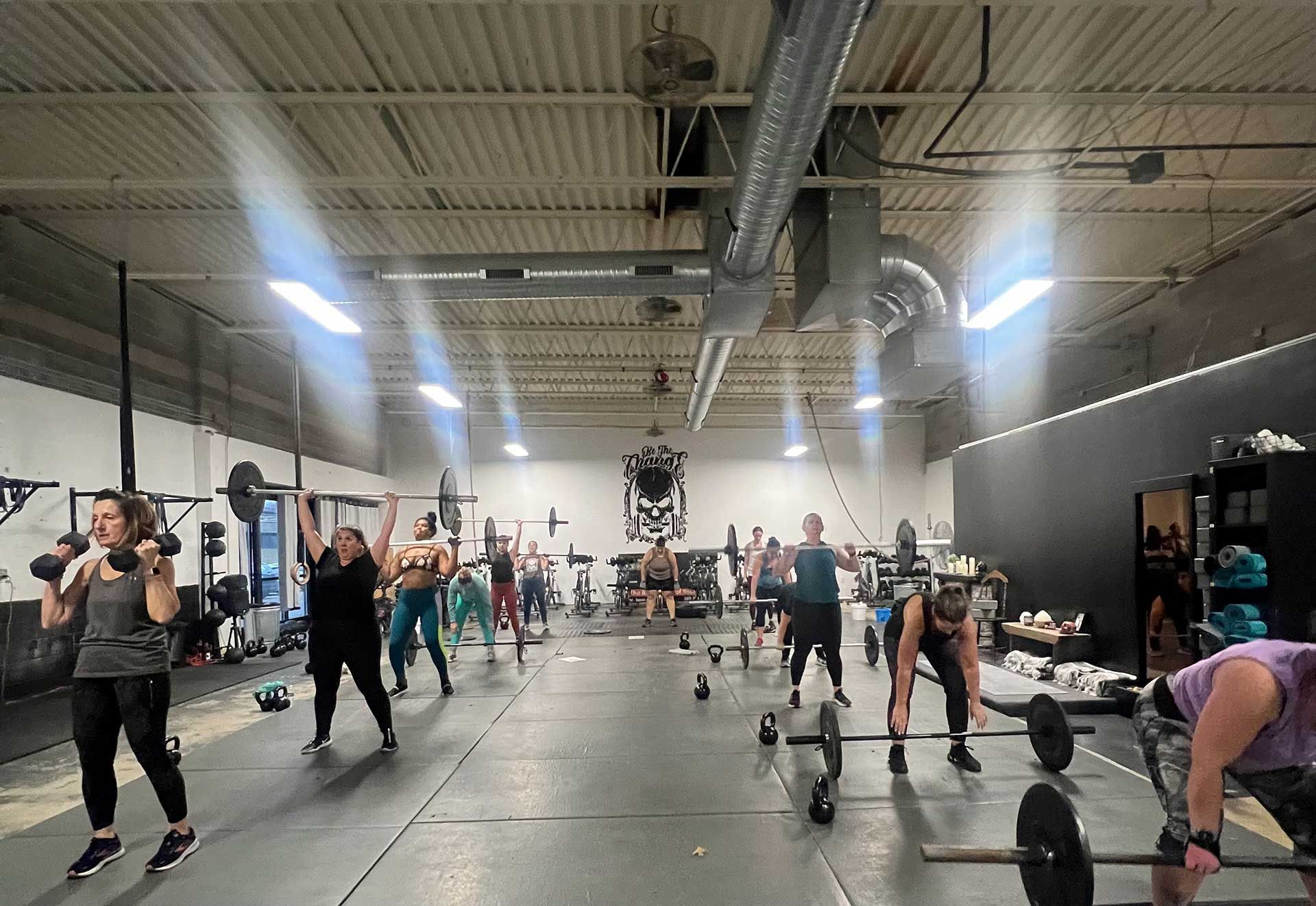 A group of women are lifting weights in a gym