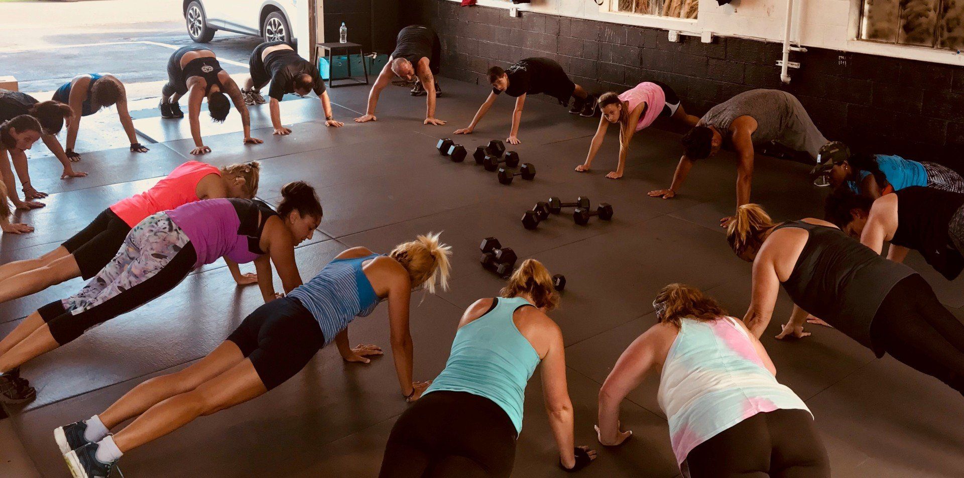 A group of women are doing push ups in a gym.