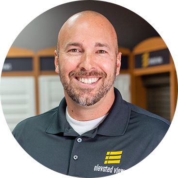 Man with a beard smiling, wearing a gray polo shirt with 
