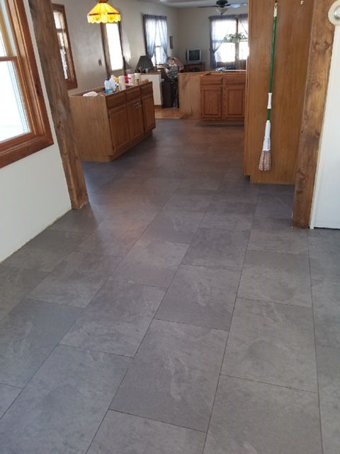 A room with a gray tile floor and a mop