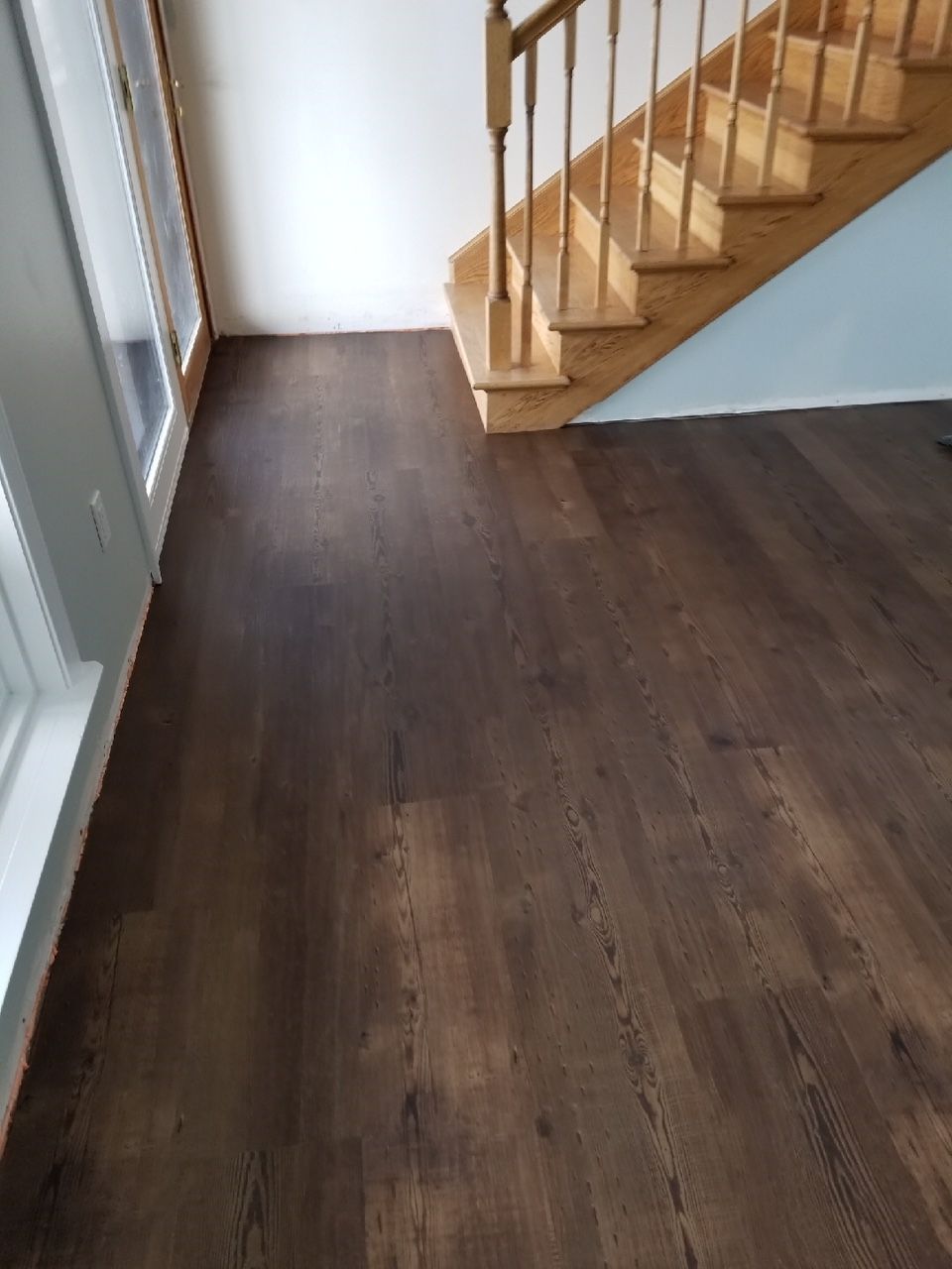 A wooden staircase with a wooden railing and a wooden floor