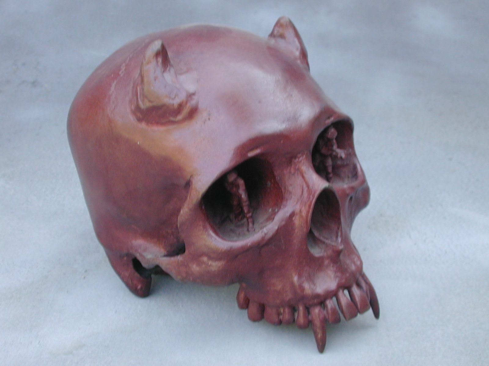 Pink human skull sculpture on a plain background